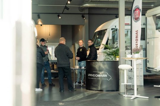 Ansatte i lokalet sammen med utstilte bobiler.