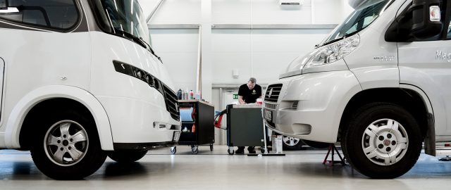 Verksted med mekaniker i bakgrunnen