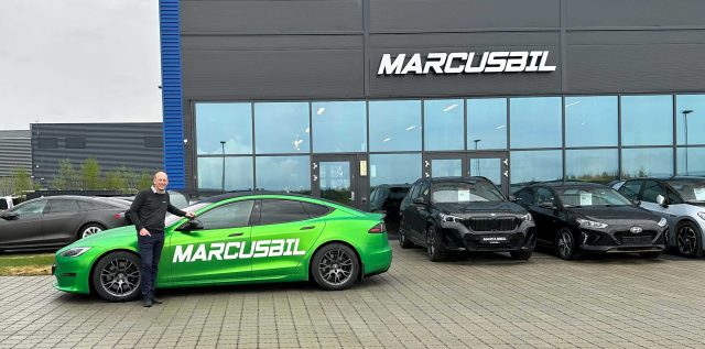 Ansatt foran grønn bil med MarcusBil foliert på siden