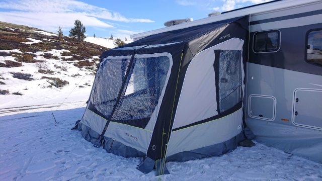 Fortelt ved siden av bobil i vinterlandskap